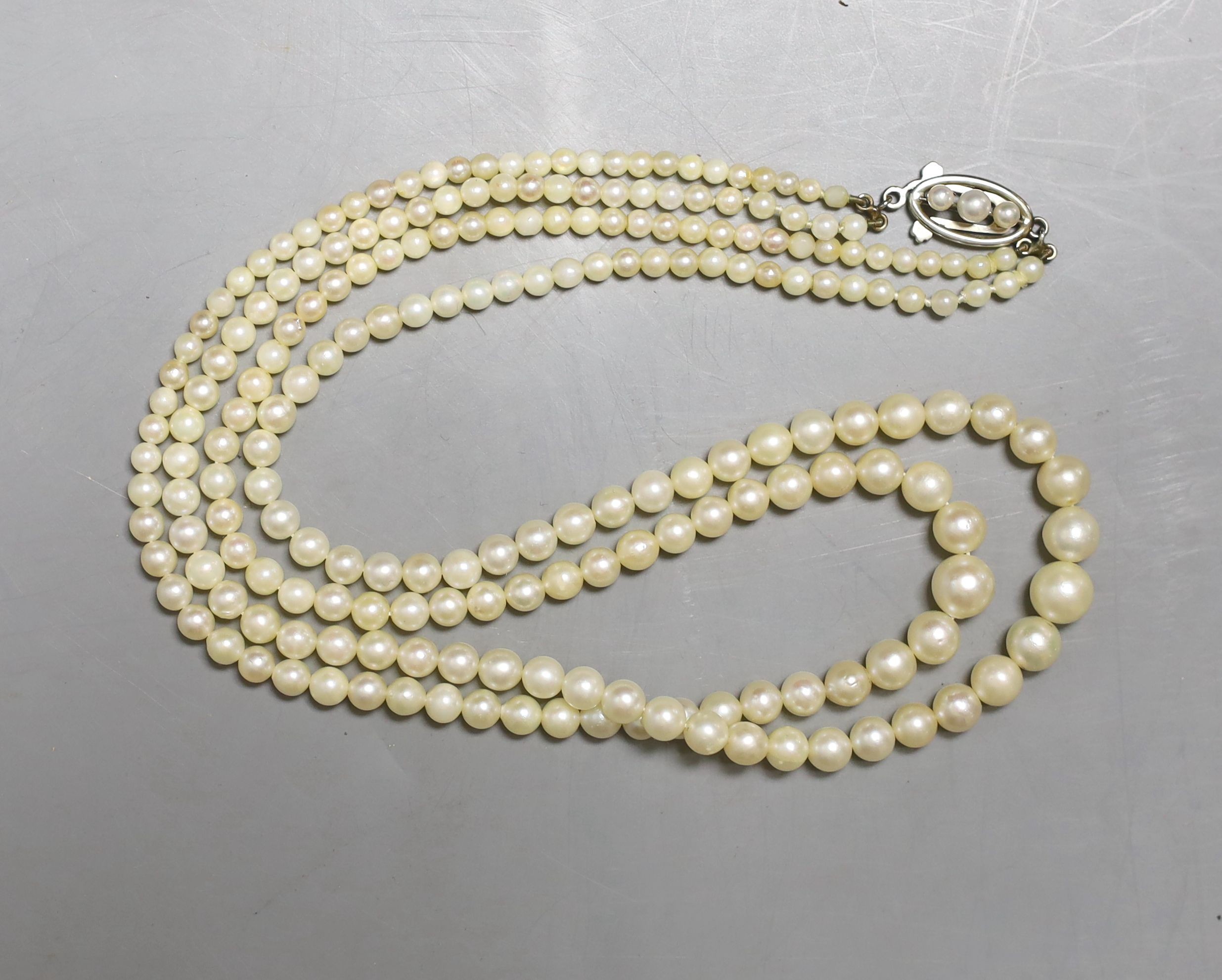 A double strand graduated cultured pearl necklace, with white metal and cultured pearl set clasp, 45cm.